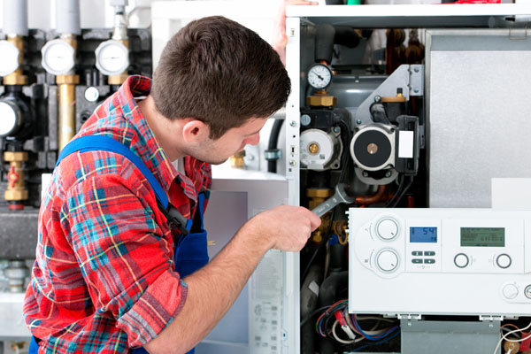 HVAC technician inspecting and repairing boiler controls in Commerce City