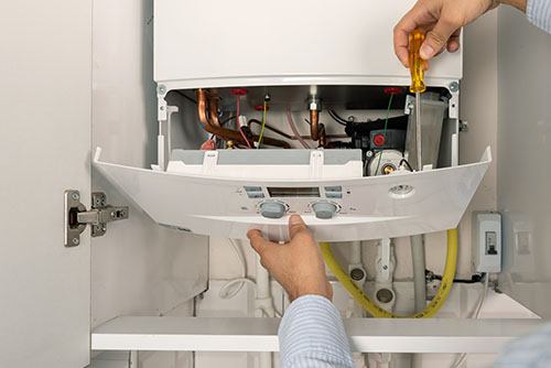 HVAC technician repairing an indoor boiler in Commerce City