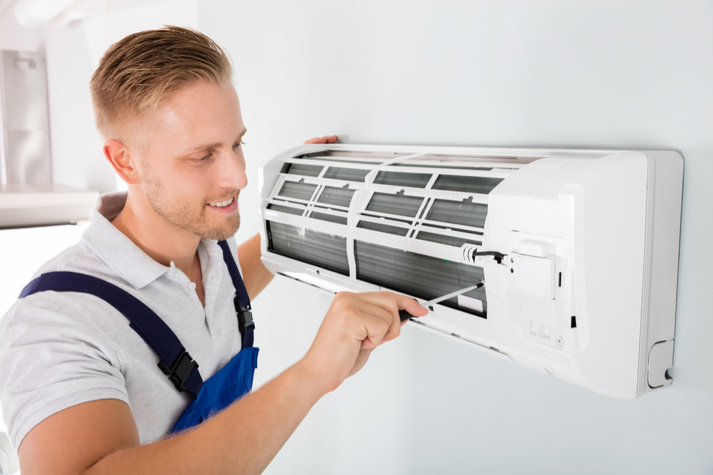 HVAC technician performing ductless air conditioning maintenance in Commerce City