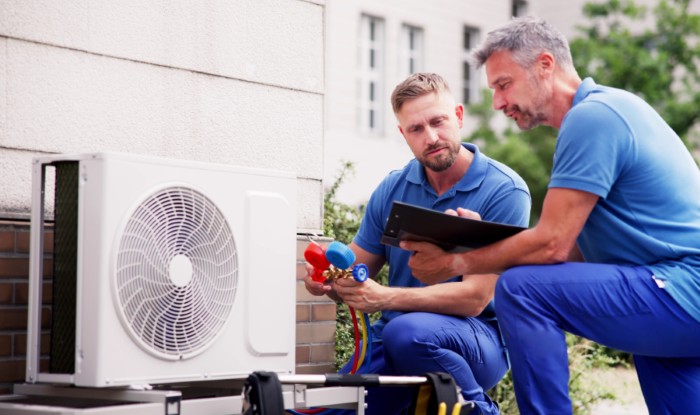HVAC technicians installing an outdoor air conditioning unit in Commerce City