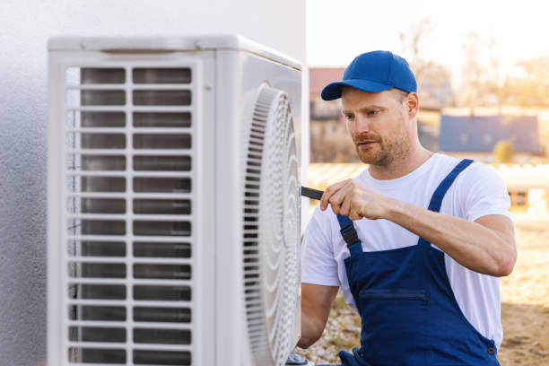 HVAC technician servicing an outdoor air conditioning unit in Commerce City