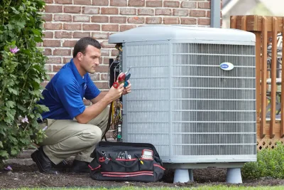 HVAC technician inspecting an outdoor air conditioning unit in Commerce City, CO